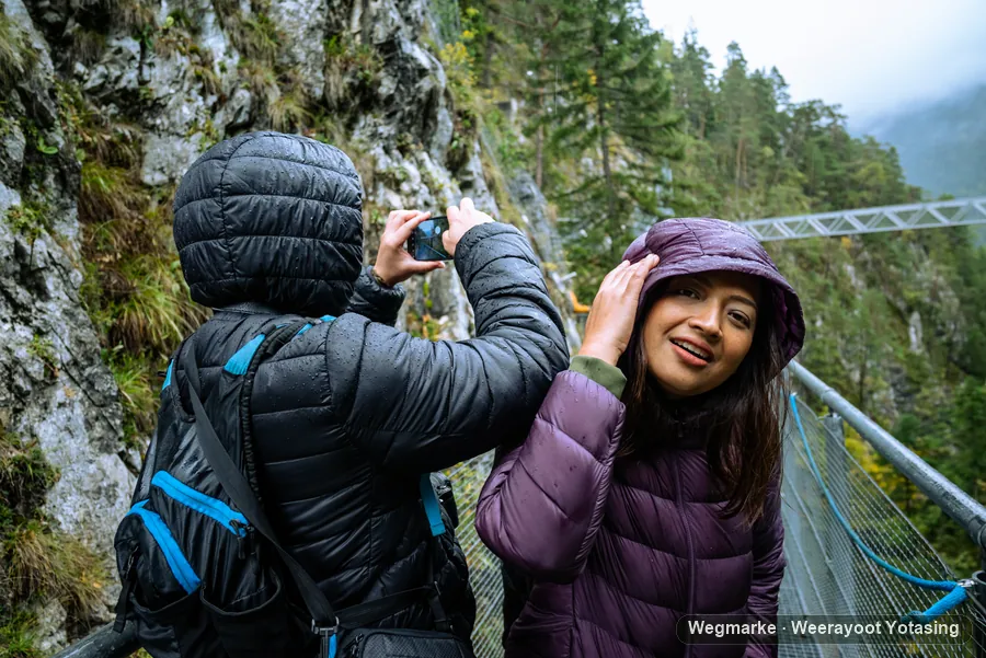 A hiker stopping to take a photograph on the trail