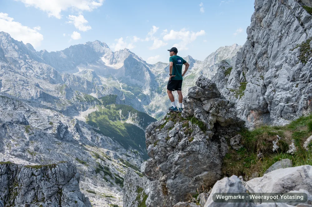 A hiker standing on the edge of a high rocky path