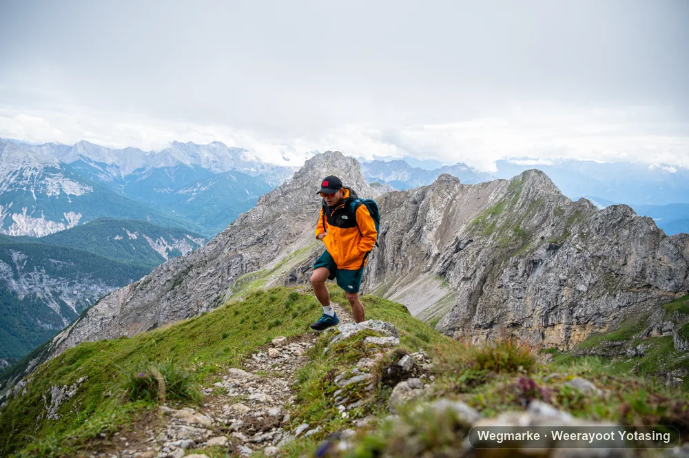 Hiker in an orange jacket on a high ridge